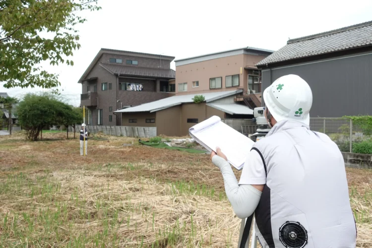 建築予定地で境界や高低差を確認する敷地調査の様子
