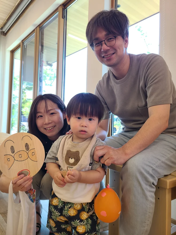 夏祭りイベントで手づくりうちわを持ち家族で記念撮影する来場者