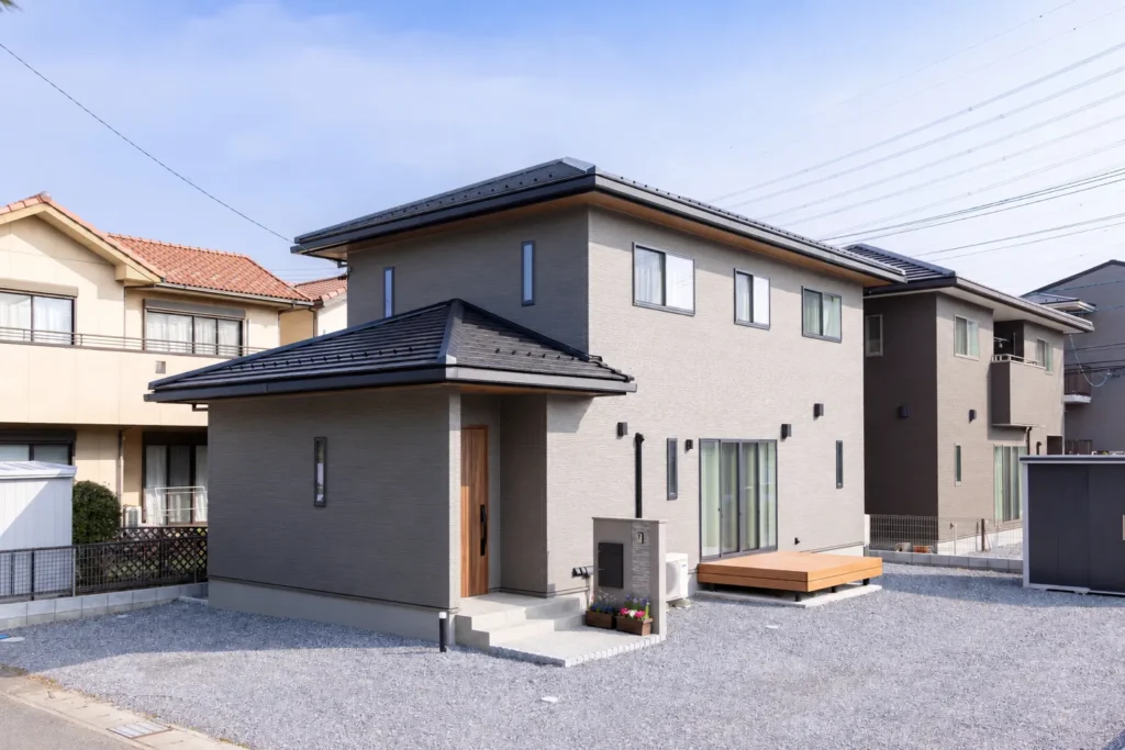木目の玄関ドアが映えるシンプルモダンな二階建て住宅の外観施工
