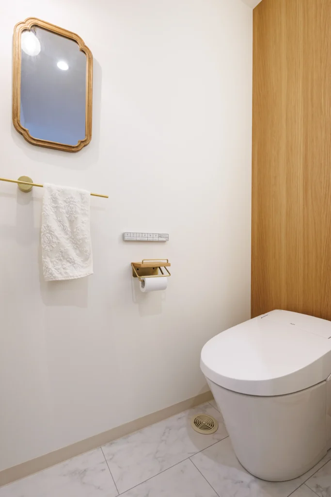 木目アクセントと真鍮アイテムを取り入れたナチュラルモダンなトイレ空間