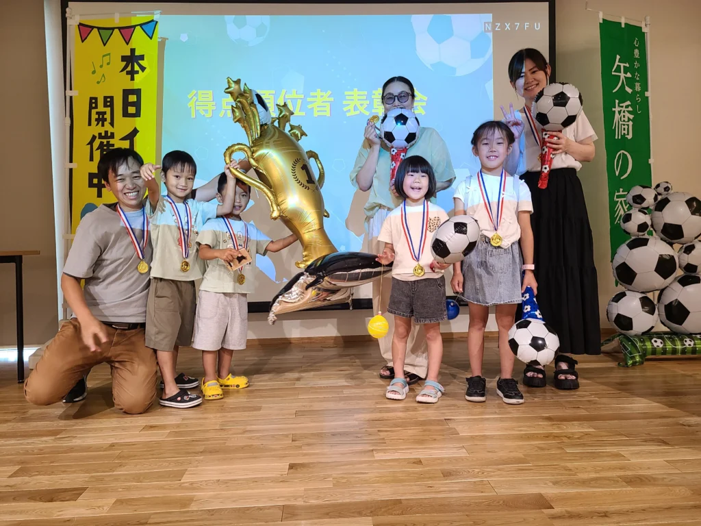 矢橋林業夏祭り2026のキックターゲット表彰式でメダルを受け取る家族